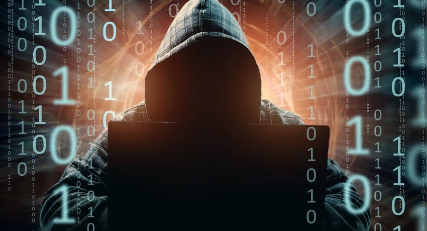 A young hacker in a hood hacks a smartphone, a hacker attack, a silhouette of a man, mixed media. The concept of a sudden attack, cryptography, data security, mobile Internet.