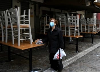 A woman stands outside a closed restaurant, amid the coronavirus disease (COVID-19) pandemic, in Thessaloniki, Greece, October 30, 2020. REUTERS/Alexandros Avramidis