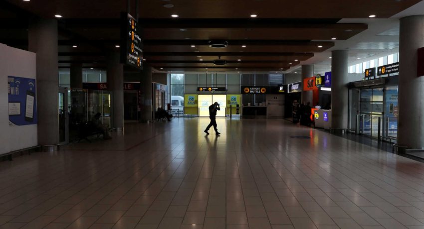 FILE PHOTO: A man walks in an almost empty arrival hall, as Cyprus government bans flights from 28 countries from March 21st  to curb the coronavirus disease (COVID-19), at Larnaca International Airport, Cyprus March 18, 2020. REUTERS/Yiannis Kourtoglou/File Photo
