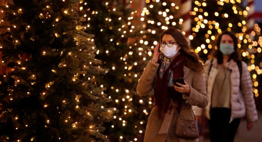 People, wearing protective face mask, walk past illuminated Christmas trees in a street in Paris, France, November 12, 2020. REUTERS/Gonzalo Fuentes