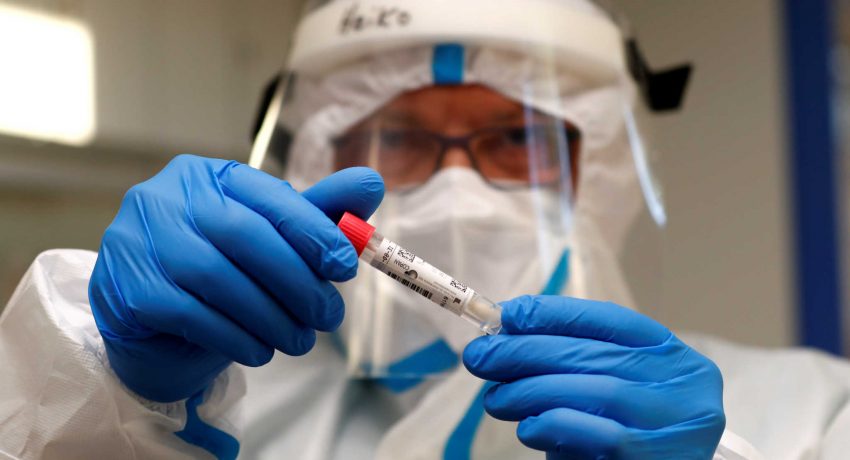 A German Red Cross medical staff holds a smear-test stick of a traveller who returned from the Ukraine, after a voluntary coronavirus disease (COVID-19) test at the new Corona test station of the central bus location in Berlin, Germany, August 5, 2020.      REUTERS/Fabrizio Bensch