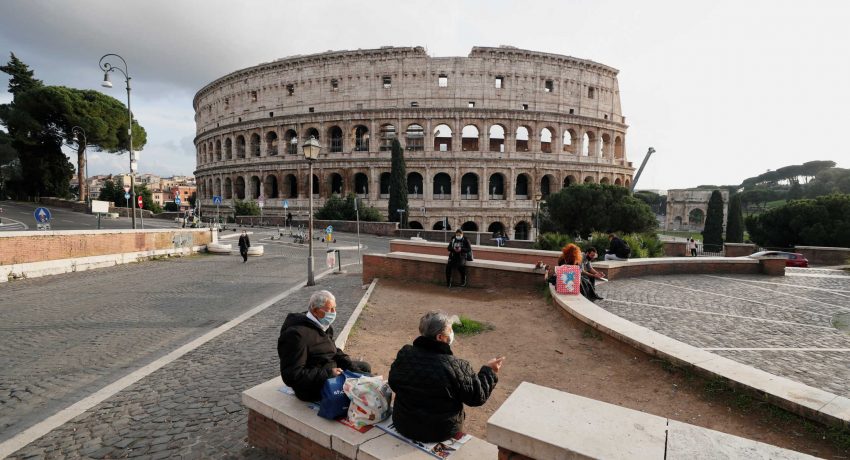 People wear protective masks as they sit near the Colosseum, as the spread of the coronavirus disease (COVID-19) continues, in Rome, Italy November 12, 2020. REUTERS/Guglielmo Mangiapane