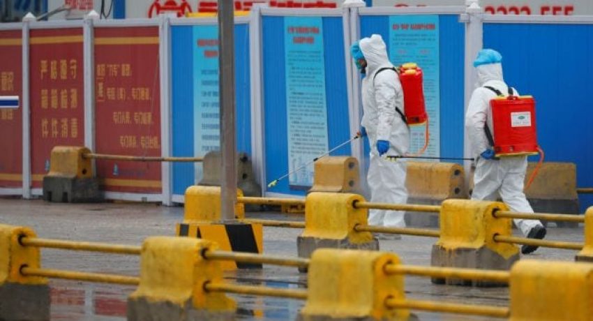 Workers in PPE spray the ground with diinfectant in Baishazhou market during a visit of World Health Organization (WHO) team tasked with investigating the origins of the coronavirus (COVID-19) pandemic, in Wuhan, Hubei province, China, January 31, 2021. REUTERS/Thomas Peter