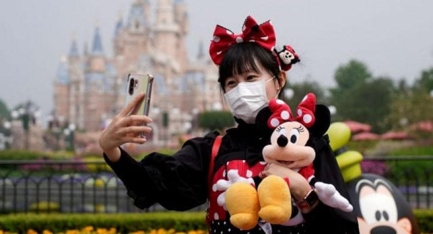 FILE PHOTO: A visitor dressed as a Disney character takes a selfie while wearing a protective face mask at Shanghai Disney Resort as the Shanghai Disneyland theme park reopens following a shutdown due to the coronavirus disease (COVID-19) outbreak, in Shanghai, China May 11, 2020. REUTERS/Aly Song/File Photo  GLOBAL BUSINESS WEEK AHEAD