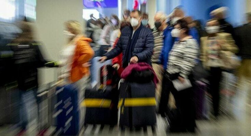 Passengers queue for a flight at the airport in Frankfurt, Germany, Saturday, Nov. 7, 2020. (AP Photo/Michael Probst)