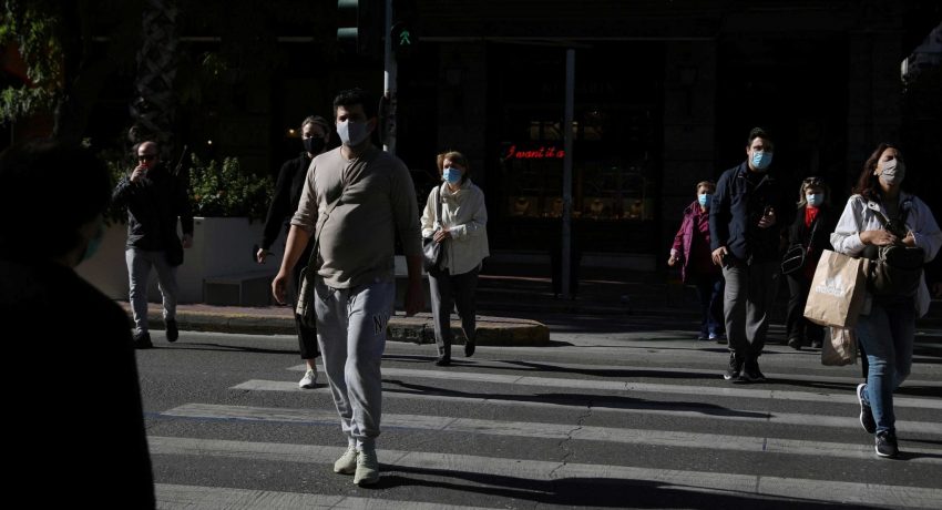 Pedestrians wearing protective face masks walk on a zebra crossing, amid the spread of the coronavirus disease (COVID-19), in Athens, Greece, October 31, 2020. REUTERS/Costas Baltas