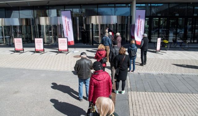People stand in line to get a vaccine against the coronavirus disease (COVID-19) outside the Stockholmsmassan exhibition center, turned mass vaccination centre, in Stockholm, Sweden, April 8, 2021. Fredrik Sandberg/TT News Agency via REUTERS     ATTENTION EDITORS - THIS IMAGE WAS PROVIDED BY A THIRD PARTY. SWEDEN OUT. NO COMMERCIAL OR EDITORIAL SALES IN SWEDEN.