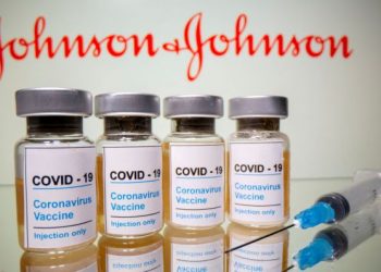 FILE PHOTO: Vials with a sticker reading, "COVID-19 / Coronavirus vaccine / Injection only" and a medical syringe are seen in front of a displayed Johnson & Johnson logo in this illustration taken October 31, 2020. REUTERS/Dado Ruvic/File Photo