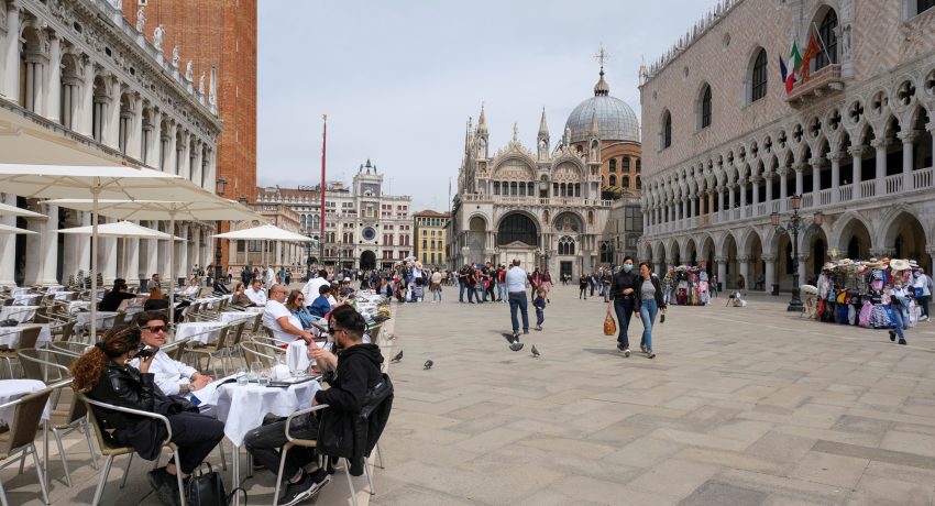 FILE PHOTO: People sit at outdoor tables at St. Mark's Square as Italy lifts quarantine restrictions for travellers arriving from European Union countries, Britain and Israel and begins offering COVID-free flights in a bid to revive the tourism industry, in Venice, Italy, May 16, 2021. REUTERS/Manuel Silvestri/File Photo