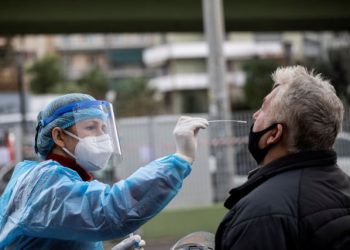 FILE PHOTO: A healthcare worker in personal protective equipment (PPE) takes a swab from a man for a rapid antigen test at a drive-through testing site, during the coronavirus disease (COVID-19) pandemic, in Athens, Greece, Dec. 18, 2020. REUTERS/Alkis Konstantinidis/File Photo