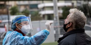 FILE PHOTO: A healthcare worker in personal protective equipment (PPE) takes a swab from a man for a rapid antigen test at a drive-through testing site, during the coronavirus disease (COVID-19) pandemic, in Athens, Greece, Dec. 18, 2020. REUTERS/Alkis Konstantinidis/File Photo