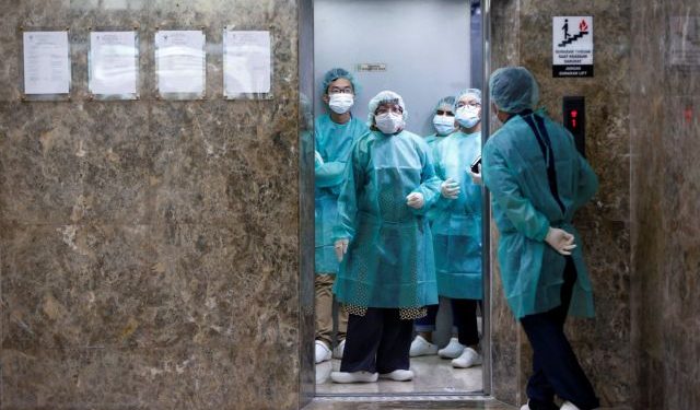 Journalists wear protective suits inside an elevator as they prepare for a media visit to Indonesian Health Ministry's Laboratorium for Research on Infectious-Diseases, following the outbreak of the new coronavirus in China, in Jakarta, Indonesia, January February 11, 2020. REUTERS/Willy Kurniawan