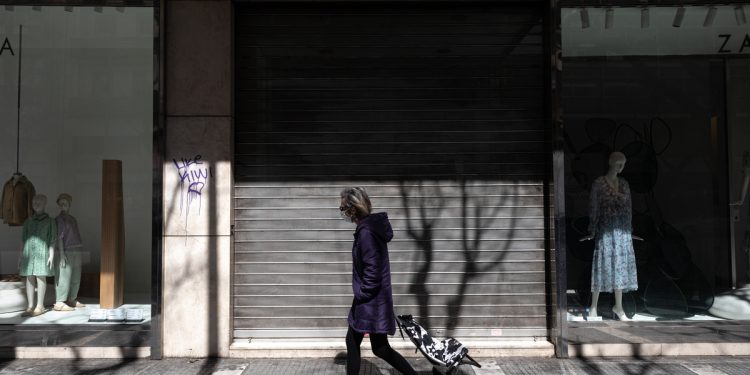 A pedestrian walks past closed shops on Tsimiski street, the main shopping street of Thessaloniki, Greece on April 7, 2020.
