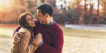 Couple in love hugging and enjoying at public park in autumn